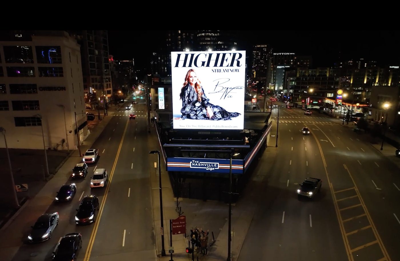 Breanna Nix Higher billboard glowing over downtown Nashville at night.