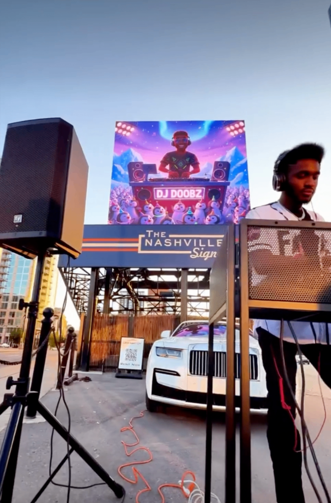Wide skyline view of the DJ activation beneath The Nashville Sign